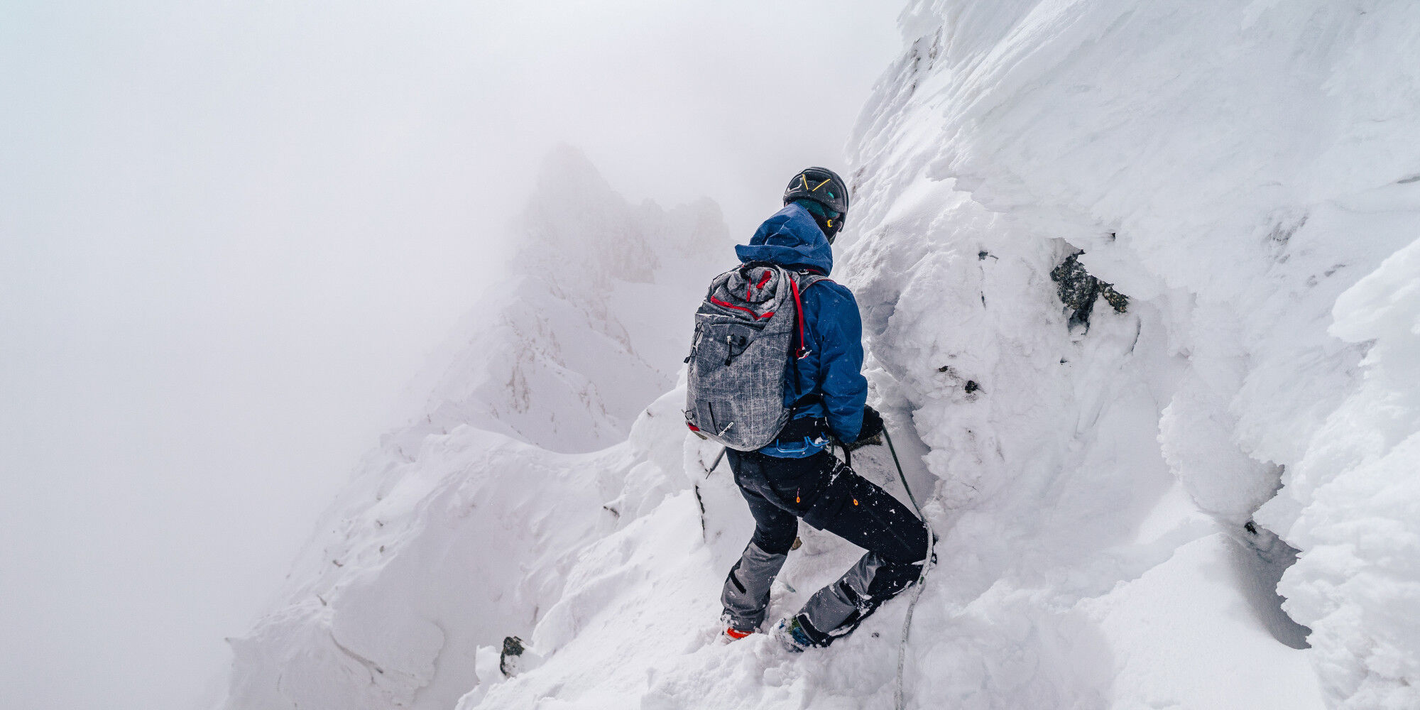 homme qui fait de l'escalade alpinisme dans la neige
				        