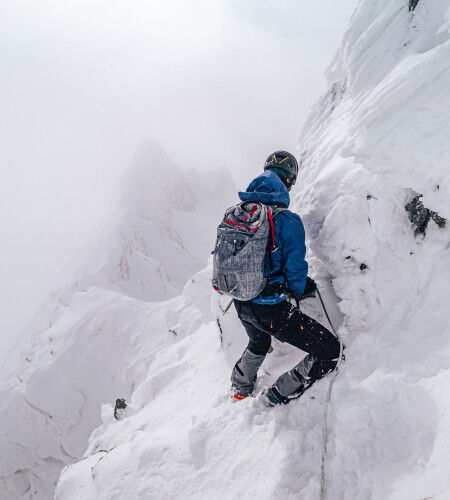 man climbing mountaineering in the snow
		                        