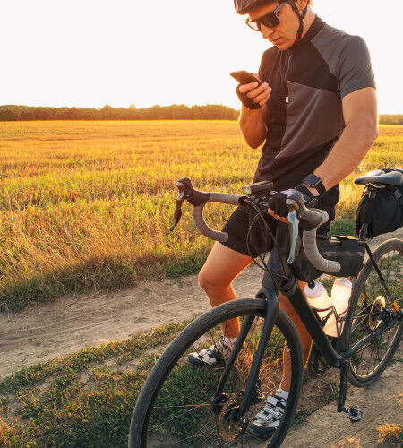 cycliste dans les champs avec des sacoches et une montre connectée
		                        