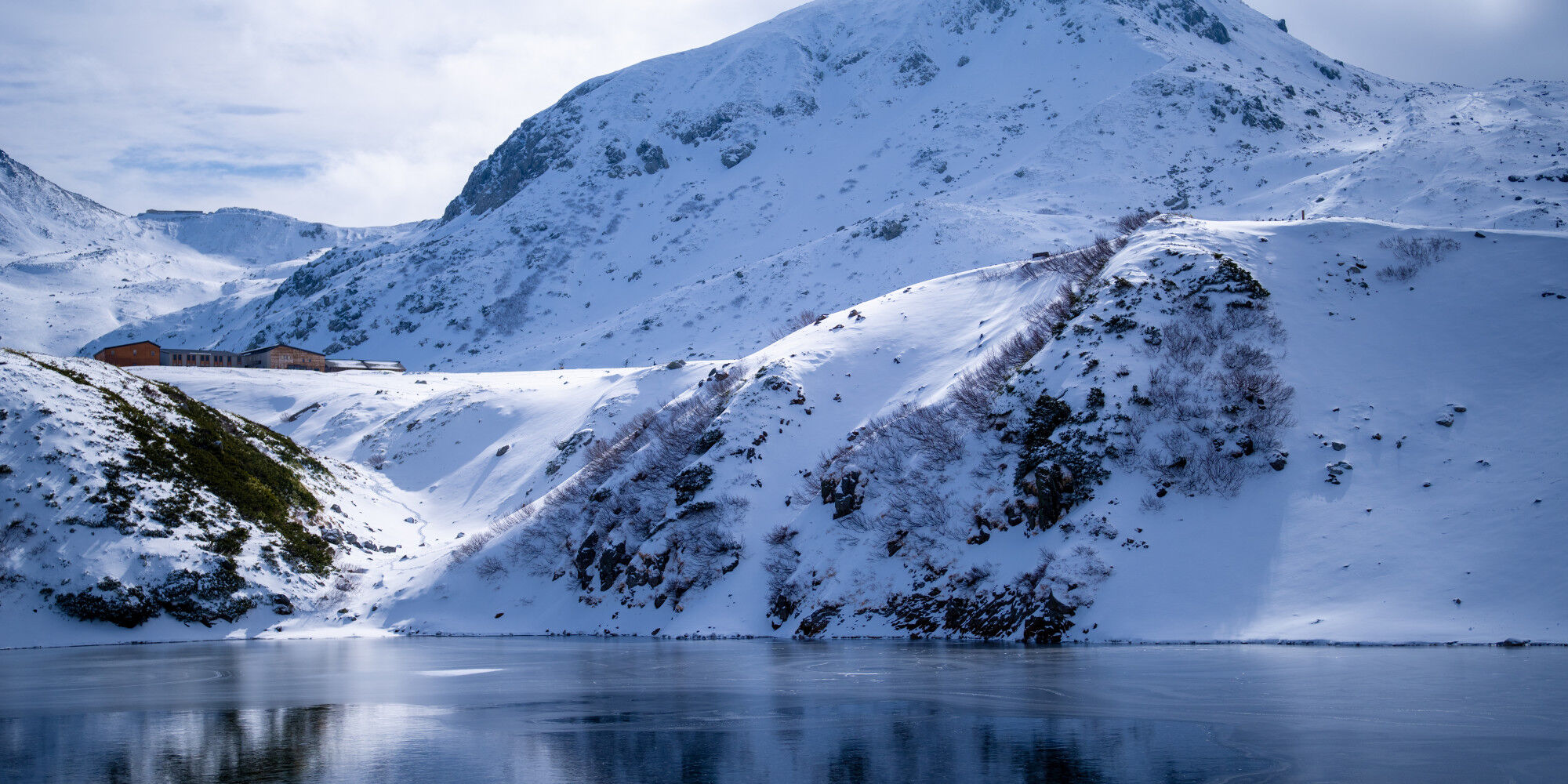 montagne enneigée et un lac gelé
				        