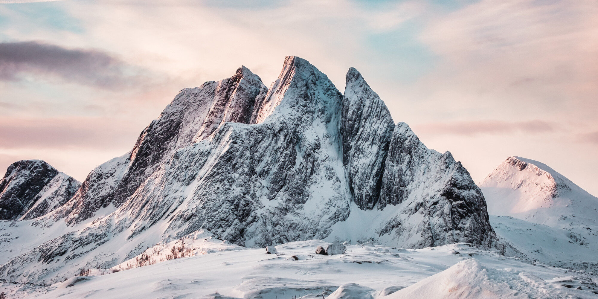 montagne enneigée avec un ciel bleu et des nuages
				        