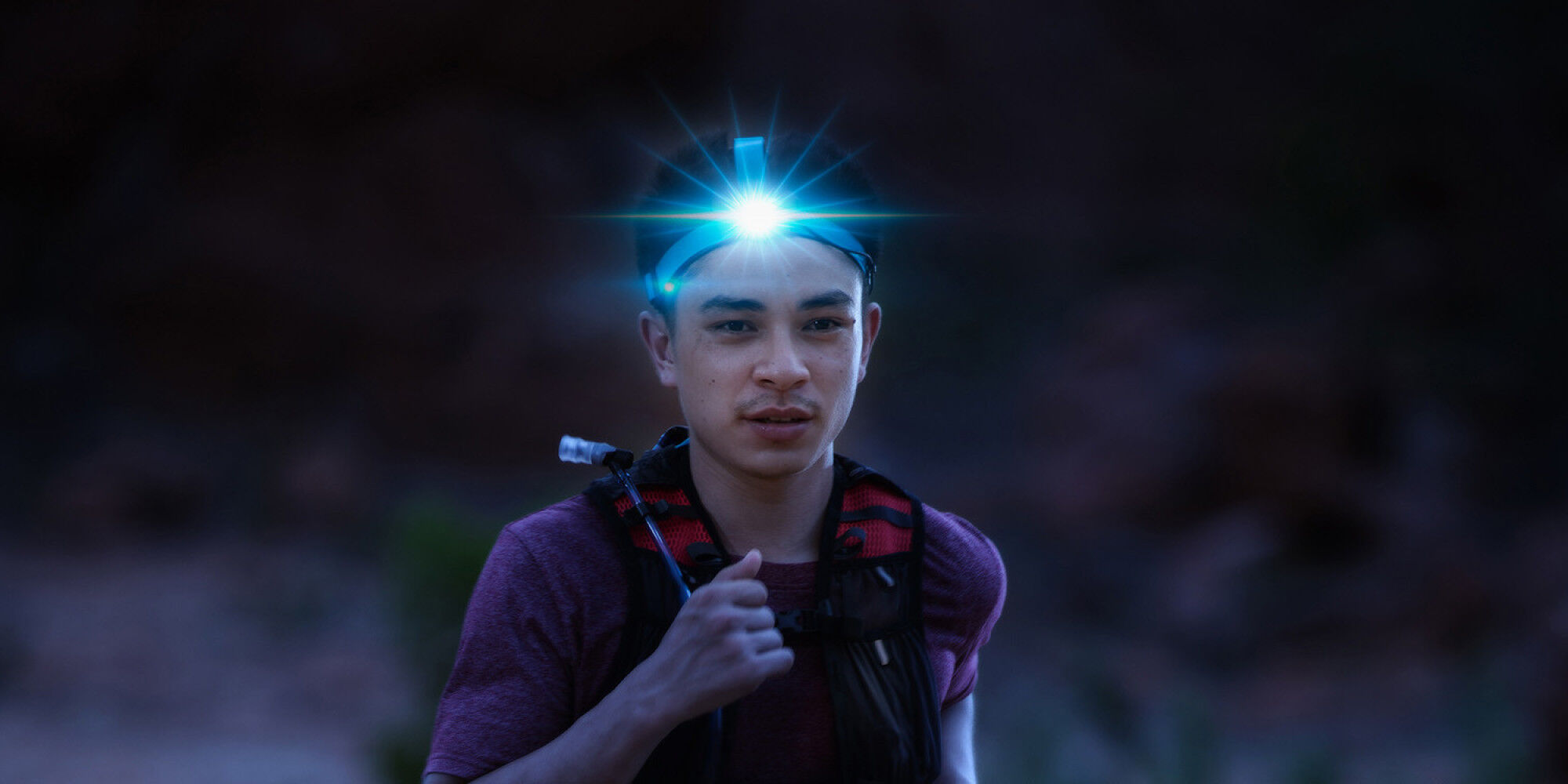 coureur de nuit avec une lampe frontale
				        