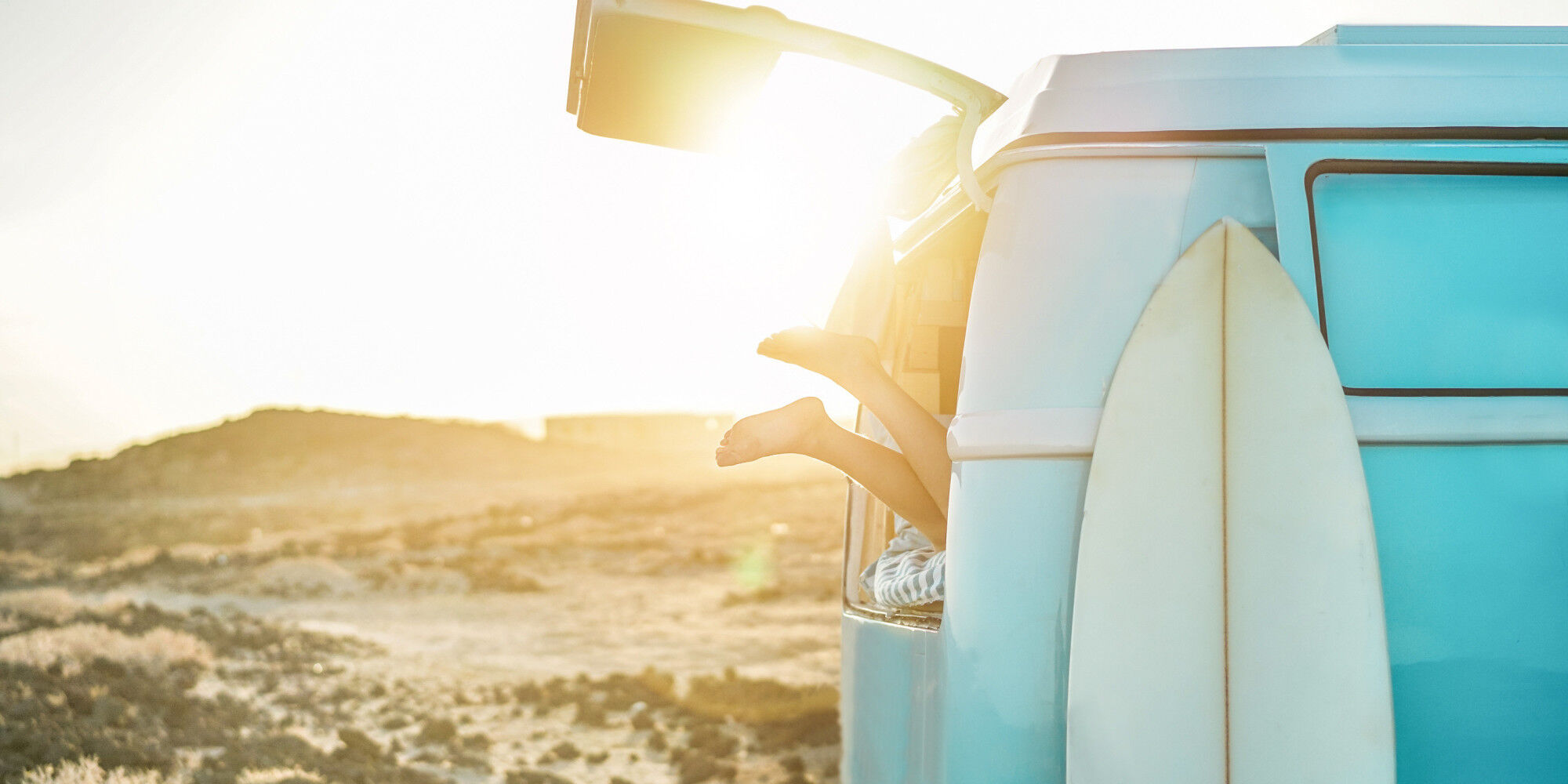 personne contente de faire du van life et rentre dans son van après le surf
				        