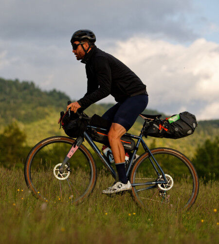 Cyclist with bike and panniers
			                        