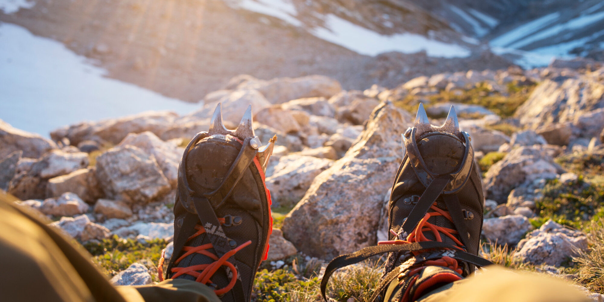 someone with crampons on their feet for a hike in the snow-covered mountains
				        