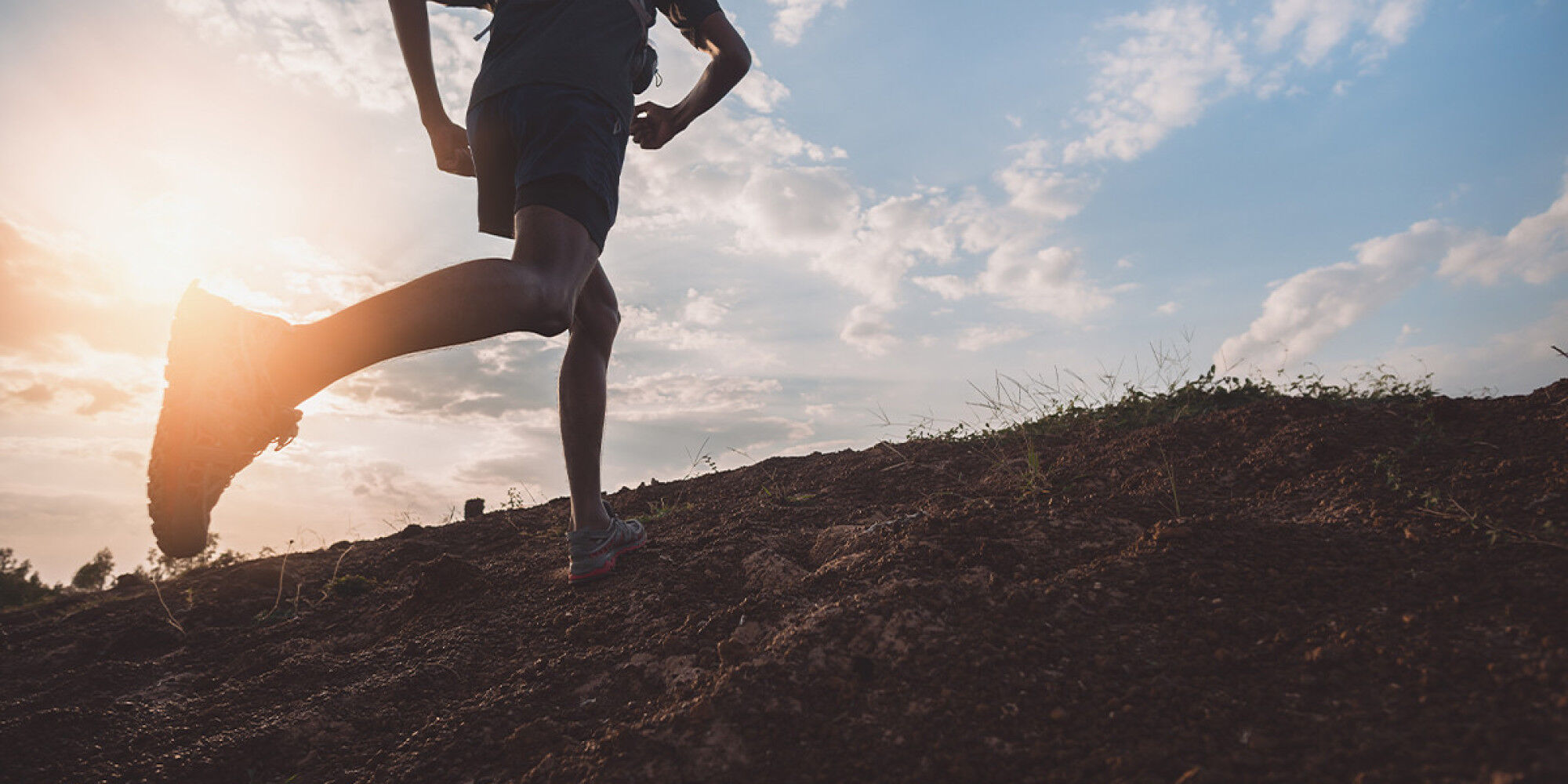 Athlete running on trail stones
				        
