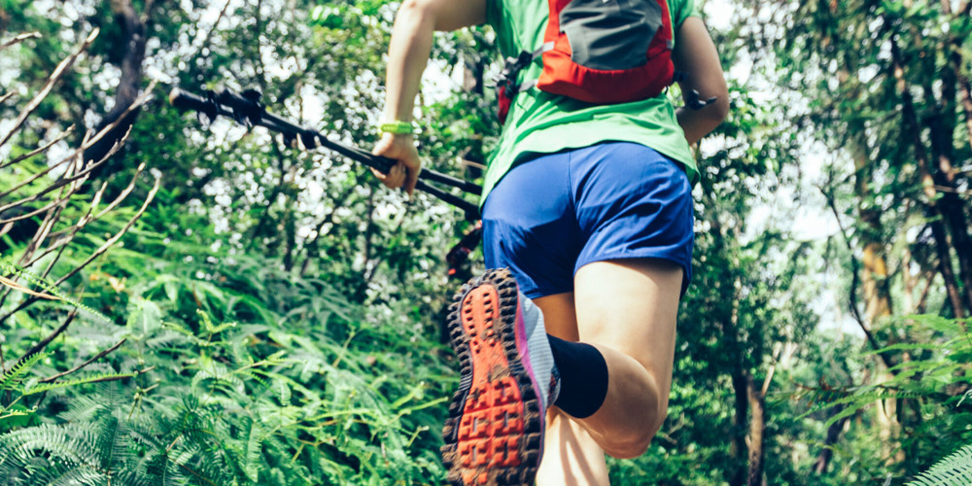 Femme qui court trail running dans la forêt
				        