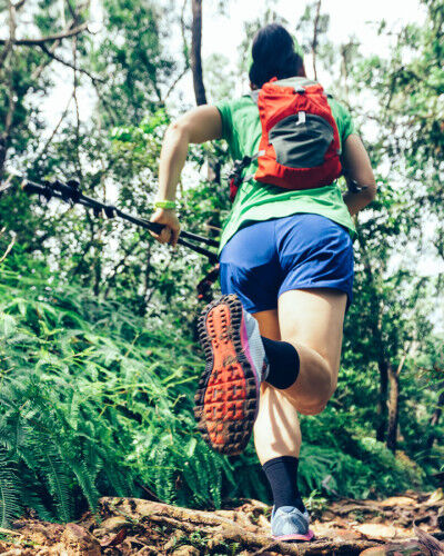 Femme qui court trail running dans la forêt
			                        