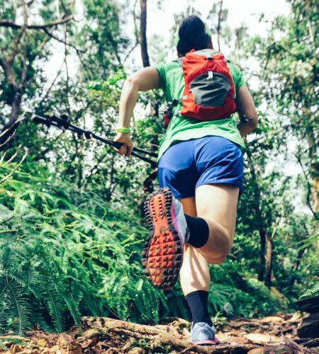 Femme qui court trail running dans la forêt
			                        