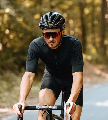 homme cycliste en vélo avec un casque et des lunettes de soleil
			                        