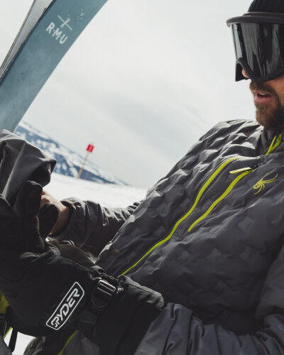 Skieur qui met ses gants Spyder
			                        