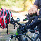 Man with helmet glove for safety riding a bicycle at countryside
			                