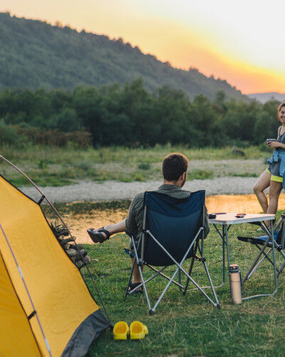 couple en camping avec du mobilier de camping
			                        