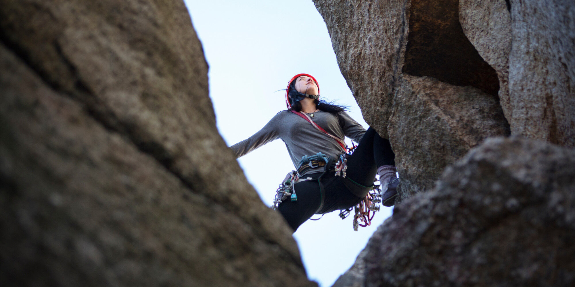 femme qui fait de l'escalade avec un baudrier
				        